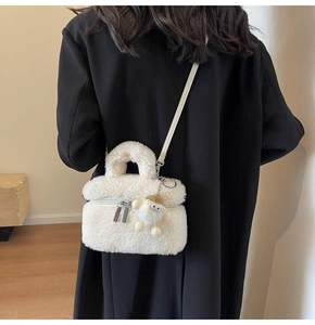 Détail du sac seau en peluche blanche avec texture douce et breloque mignonne