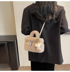 Vue détaillée du sac seau en peluche beige avec texture laine et breloque mouton sur modèle
