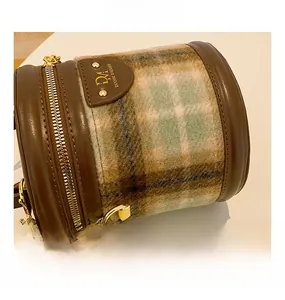 Détail du sac seau style vintage anglais en laine à carreaux et patchwork de cuir brun