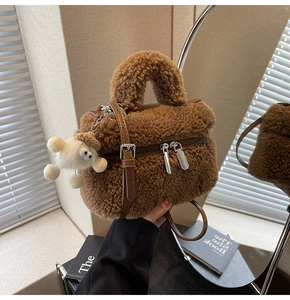 Détail du sac seau en peluche marron avec double zip et charmant pendentif petit agneau