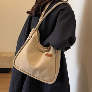 Large khaki canvas shoulder bag for women with minimalist bucket design and side pocket