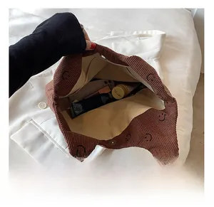 Vue intérieure du cabas en velours côtelé marron montrant sa grande capacité et son fermoir