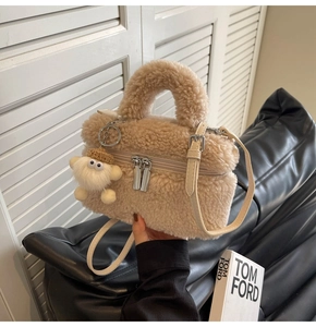 Détail du sac seau beige en peluche avec texture douce et breloque monstre mignonne