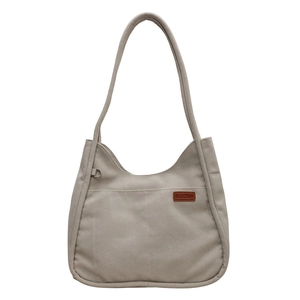 Minimalist grey canvas tote bag with leather logo patch and silver D-ring detail