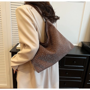 Dettaglio macro di una borsa hobo in pelle scamosciata marrone con strass argento lucidi