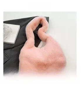 Dettaglio della trama della borsa in ecopelliccia rosa con materiale morbido e manico