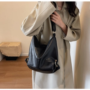 Detail of black large hobo bag with natural PU texture and golden metal buckle