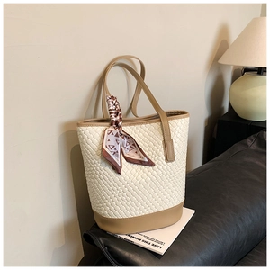 Detail of woven bucket tote with khaki leather trim and decorative silk scarf accessory