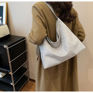 Detalle del bolso hobo de strass plateado con cristales brillantes y correa de cuero premium