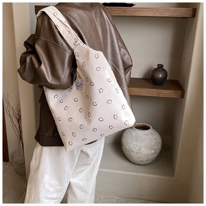 Détail du sac fourre-tout en velours côtelé blanc cassé avec motifs smiley noirs