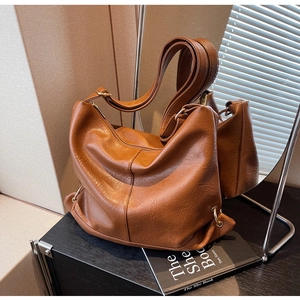 Detail of vintage brown PU leather tote bag showing soft texture and metal buckle