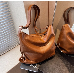 Detail of caramel brown PU leather hobo bag with litchi texture and metal ring