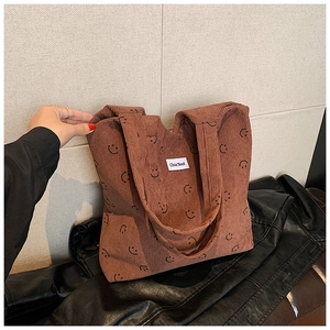 Détail du sac cabas en velours côtelé marron rouge avec smileys et étiquette tissée