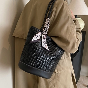 Large black woven leather bucket bag with white contrast stitching and silk scarf accessory