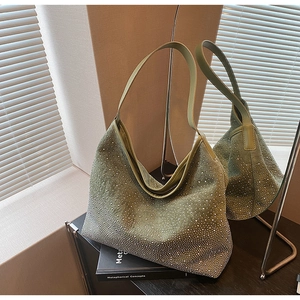 Dettaglio di una borsa hobo in pelle scamosciata verde con cristalli e strass argentati