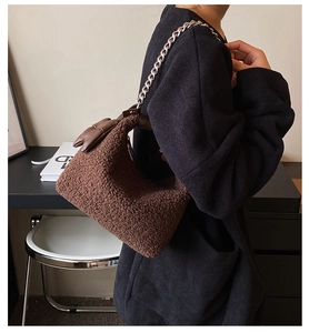 Détail du sac bandoulière marron en peluche avec chaîne argentée et nœud en cuir élégant