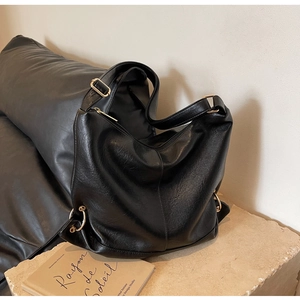 Detail of adjustable gold buckle on high-quality black hobo bag with matte finish