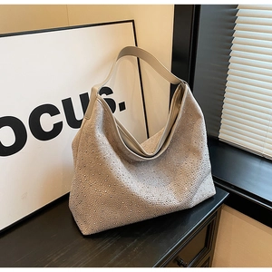 Vista dettagliata della borsa hobo beige ricoperta di strass argentati brillanti