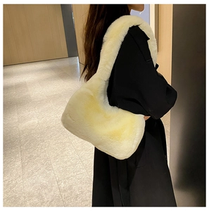 Dettaglio di una grande borsa a spalla in peluche crema con texture in finta pelliccia