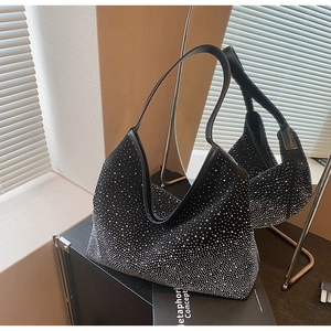 Dettaglio della borsa a mezzaluna nera con strass scintillanti su una superficie a specchio
