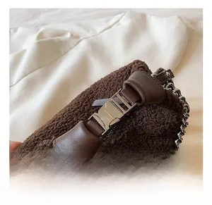Gros plan sur le sac en peluche marron avec bandoulière en chaîne argentée et fermoir métal