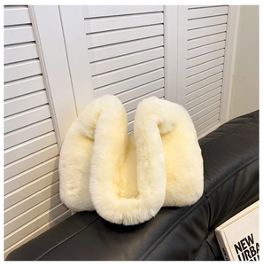 Vista dettagliata della borsa a mezzaluna in peluche bianco crema con texture morbida