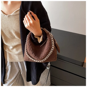 Détail du sac en peluche marron foncé avec chaîne argentée et imitation laine d'agneau