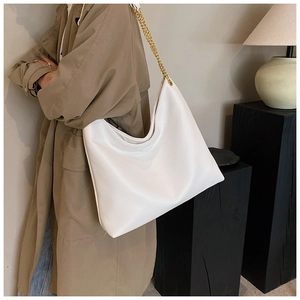 Détail du sac hobo blanc avec texture litchi et élégante bandoulière en chaîne dorée