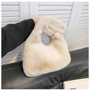 Dettaglio borsa in peluche color crema con consistenza morbida e design a manico singolo