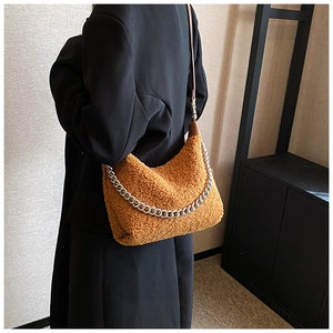 Détail du sac à main marron en polaire avec chaîne en métal argenté et bandoulière en cuir