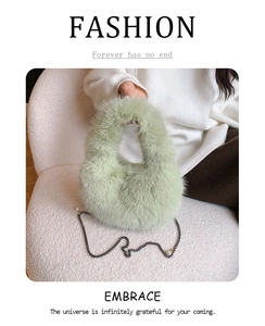 Primer plano de bolso de peluche verde claro con cadena metálica y decorado de perlas
