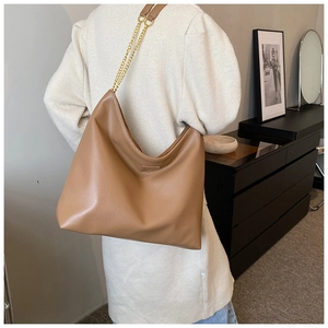Détail d'un sac hobo en cuir PU marron avec bandoulière chaîne dorée et fermoir triangulaire