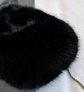 Vista de detalle de la textura de felpa negra densa y cadena de metal en el bolso