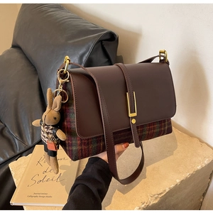Close-up of retro crossbody bag with check patterns and a cute bunny plush charm