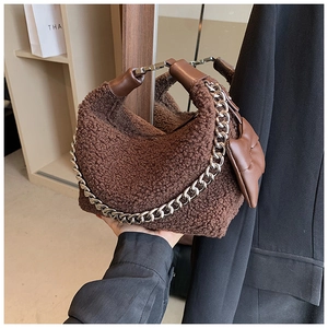 Détail du sac en peluche marron effet mouton avec chaîne argentée et anse en cuir