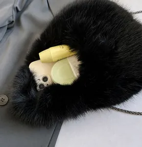 Detalle de la capacidad interior de este bolso de hombro de felpa negra con cadena
