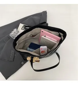 Detail of quilted black tote bag interior showing large capacity and internal pockets