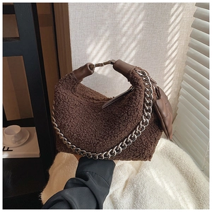 Détail du sac à main en peluche marron foncé avec chaîne argentée et poignée cuir