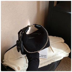 Détail de la texture peluche noire et bandoulière en chaîne argentée du sac