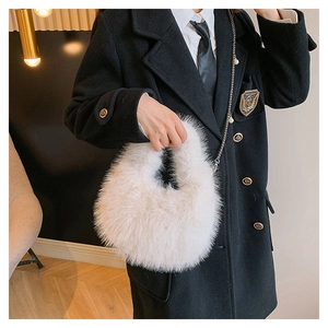 Primer plano del bolso de peluche blanco roto con cadena de plata en el modelo real