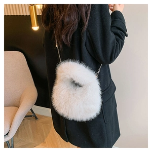 Detalle del bolso de pelo sintético blanco con cadena metálica fina en dorado
