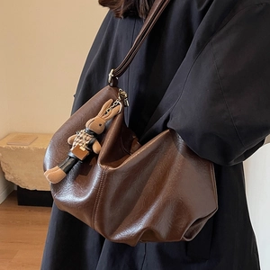 Retro dark brown pleated dumpling bag with cute plush rabbit charm on leather shoulder strap