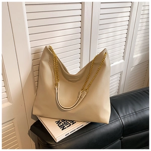 Détail du sac seau hobo beige avec texture cuir grainé et bandoulière en chaîne dorée