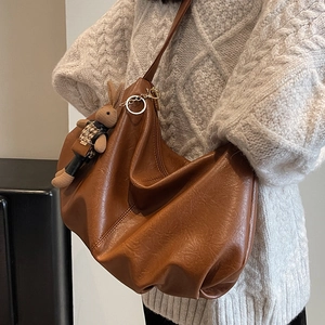 Retro caramel brown hobo shoulder bag with pleated texture and rabbit doll charm