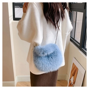 Detalle de bolso de piel sintética azul claro con cadena metálica en modelo