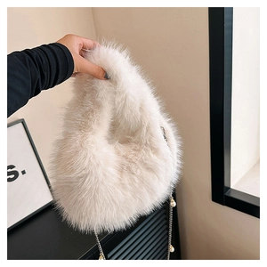 Detalle de bolso de peluche con cadena dorada y cuentas de perlas decorativas