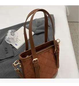 Detailansicht der braunen Eimertasche aus Mattleder mit gestepptem Rautenmuster