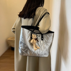 Large capacity silver quilted tote bag with black leather straps and bear charm detail