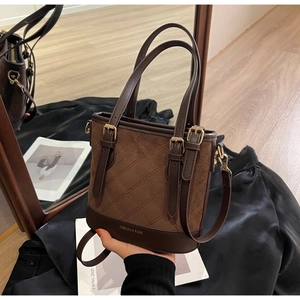 Detail einer braunen Eimer-Tasche mit Rautensteppung und verstellbarem Schultergurt