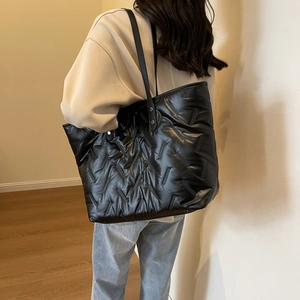 Minimalist black quilted tote bag for women featuring a glossy finish and large capacity